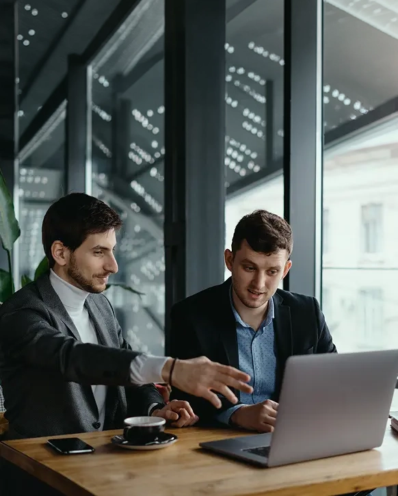 Two businessmen reviewing data on a laptop